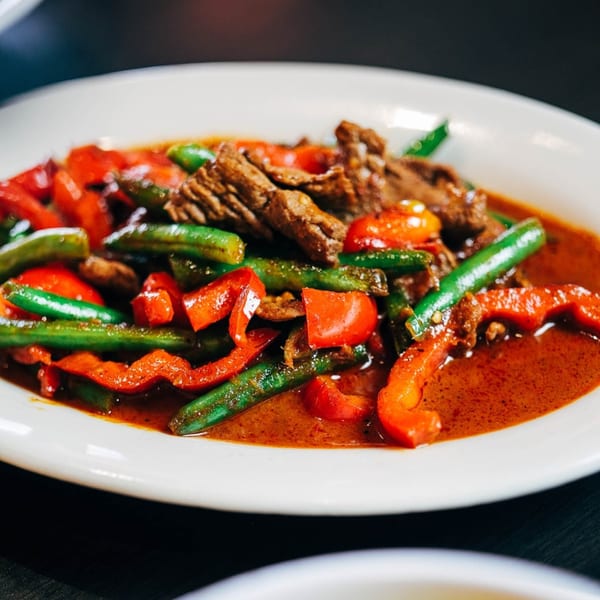 Spicy beef stir-fry with red bell peppers and green beans in a rich red sauce.